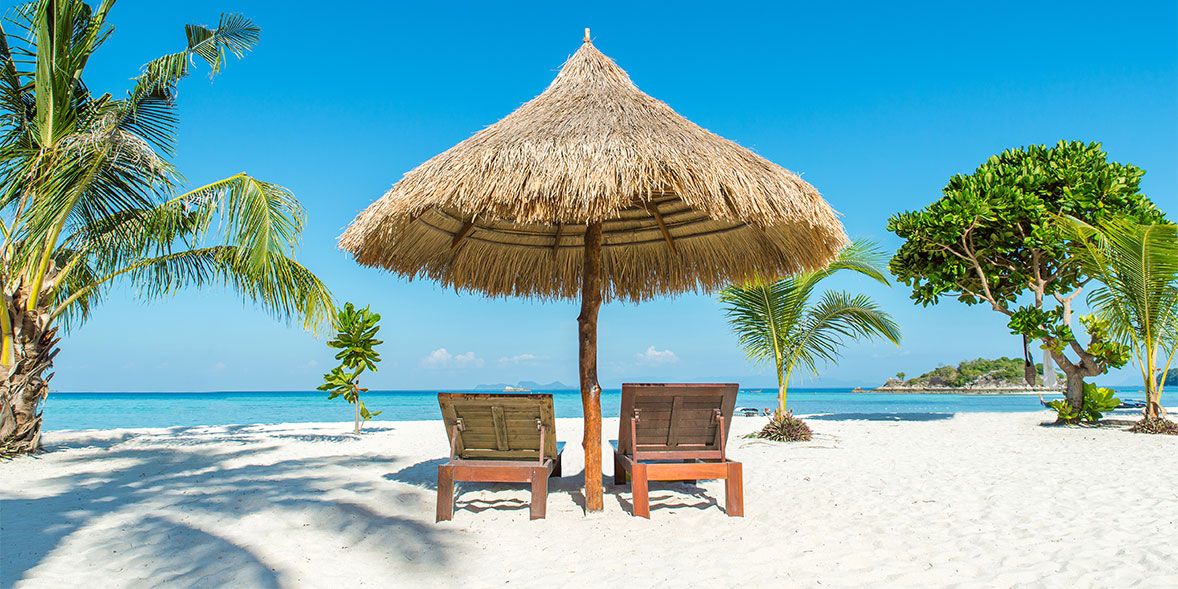 Chairs underneath an straw umbrella on a sunny beach